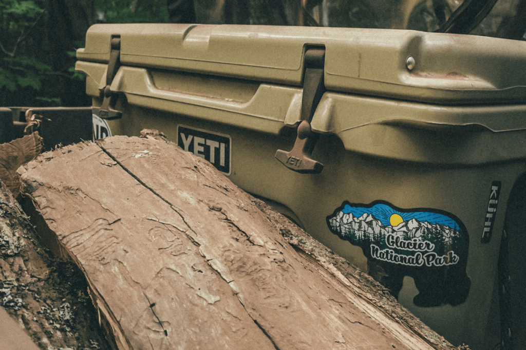 a photo of a Yeti Cooler at a camp site in the woods.