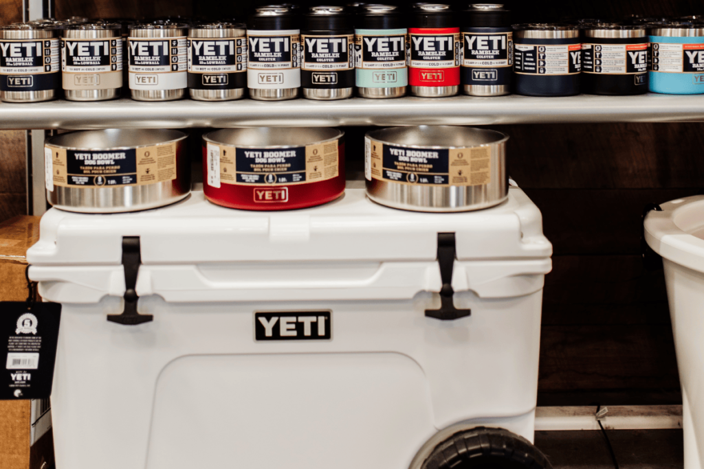 a photo of various Yeti products on a store shelf. Coolers, dog bowls and mugs.